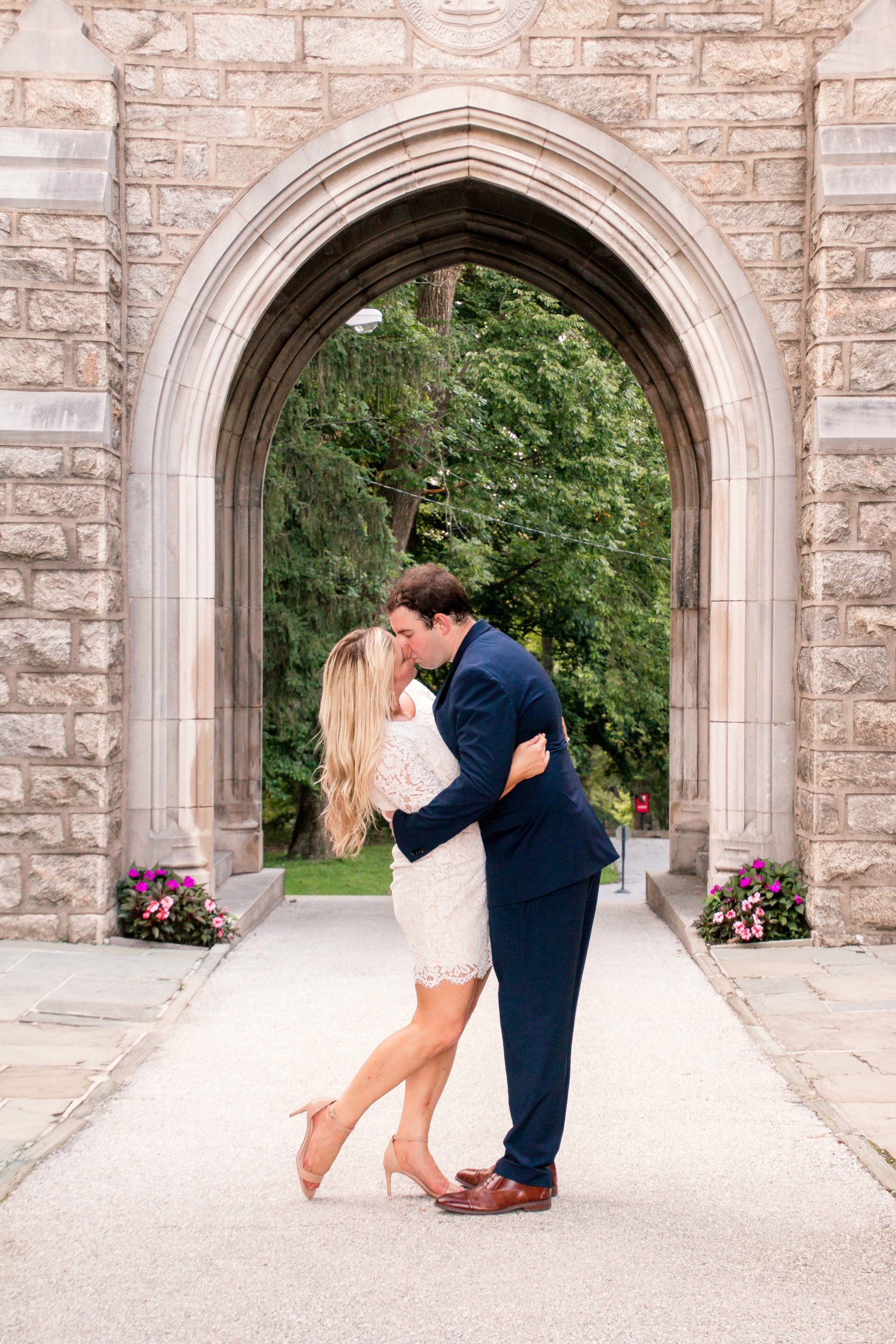 Woman in a white dress kissing a man in a blue suit in front of a Philadelphia wedding chapels